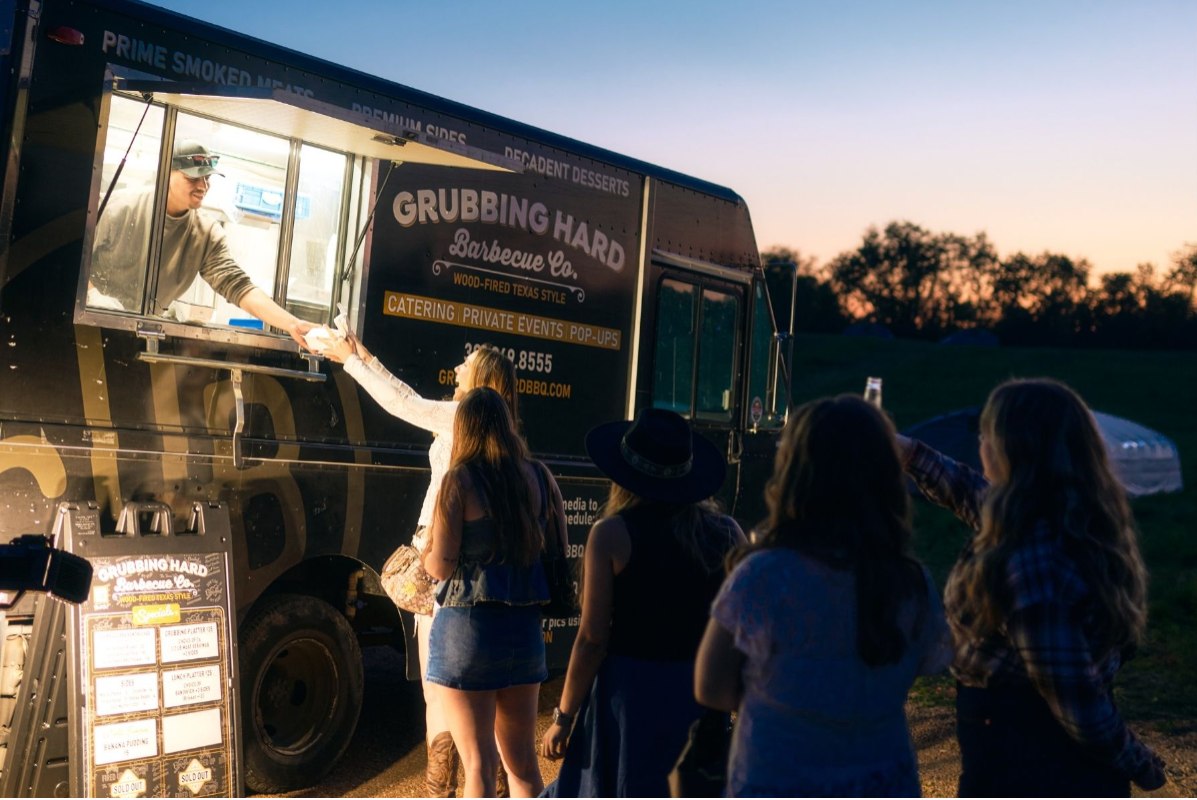 Grubbing Hub BBQ food truck at sunset with people in line