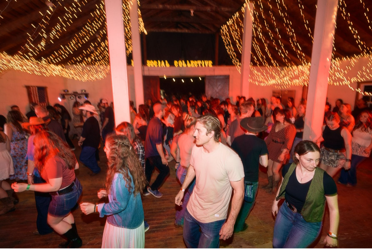 Couples country dancing in a string-lit barn