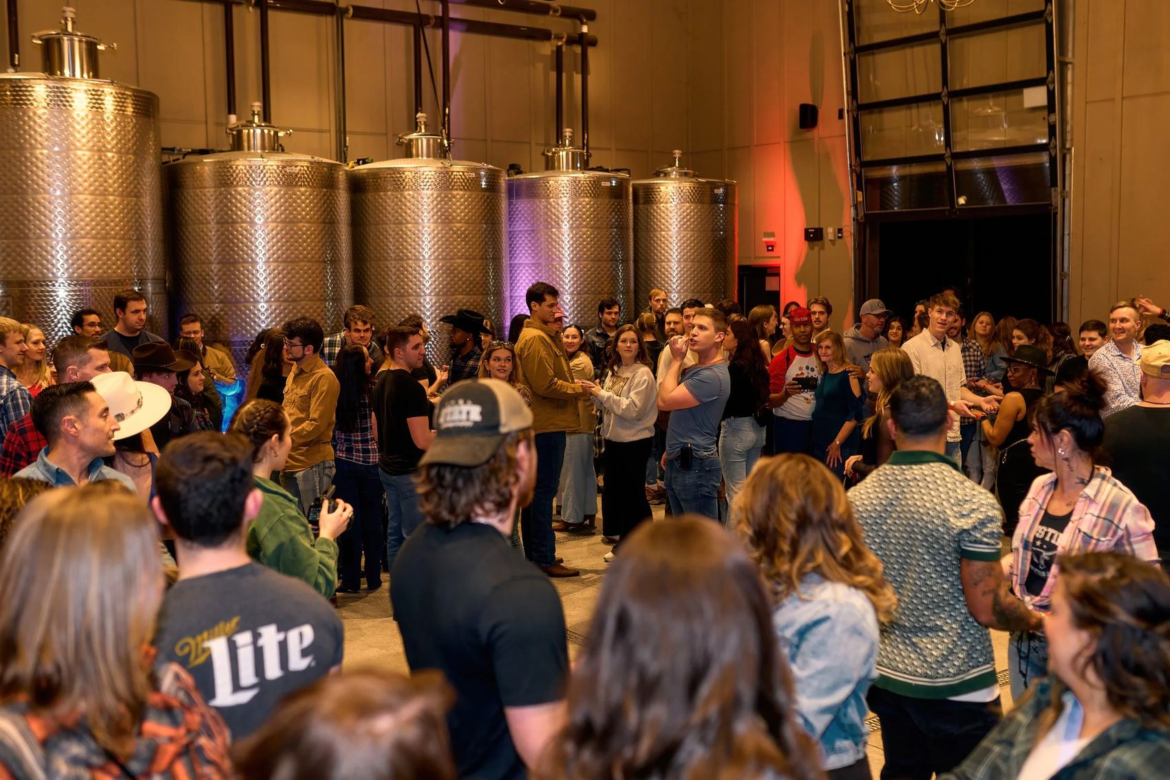 A room full of young adults at a winery night